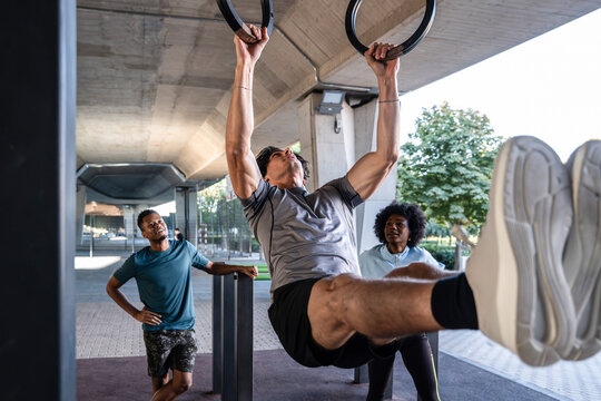 Outdoor calisthenics ring workout with friends coaching