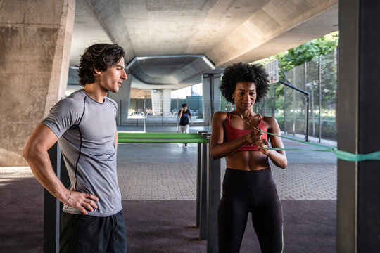 Outdoor resistance band workout with trainer under bridge