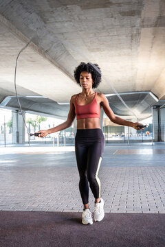 Woman skipping rope under overpass for cardio workout