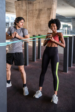 Outdoor partner workout with resistance band in urban gym