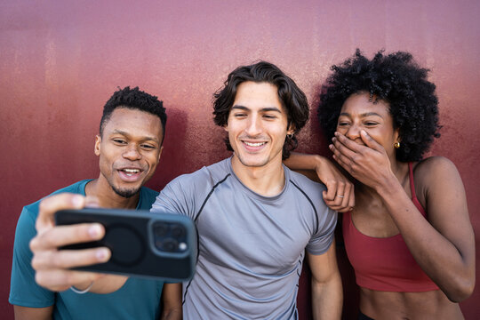 Friends taking a smartphone selfie after workout outdoors