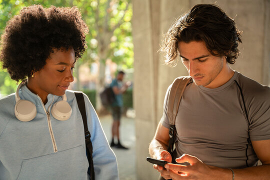 Two college students checking a smartphone on campus