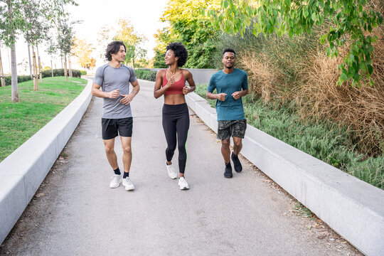 Friends jogging together on a park path in morning light