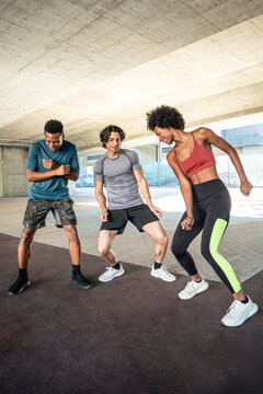 Group of friends doing dance workout in urban space