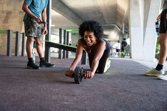 Outdoor ab wheel workout session under urban overpass