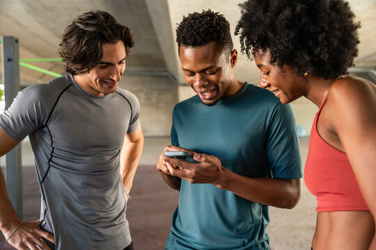 Friends checking fitness app on smartphone at gym together