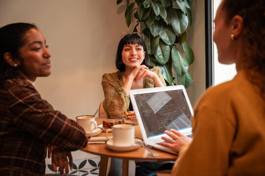 Multiethnic coworker meeting with laptop in cafe