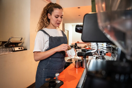 Barista preparing espresso with portafilter at coffee bar
