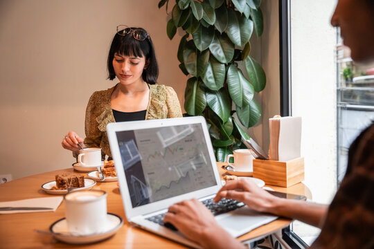 Multiethnic coworkers working on laptop in cafe meeting