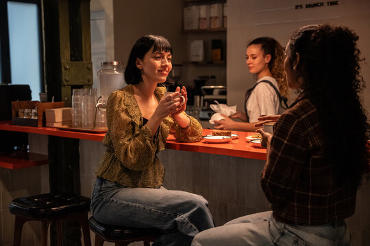 Multiethnic women chatting over coffee in a cozy cafe