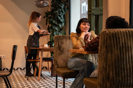 Friends chatting in cozy cafe booth during casual meetup