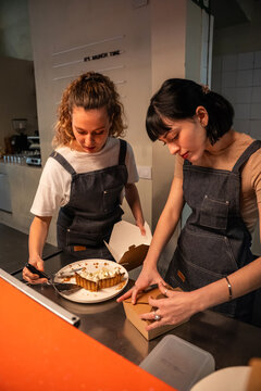 Bakery staff packing dessert in box at cafe counter
