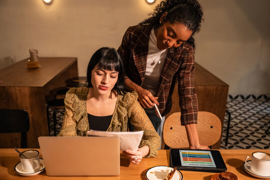 Multiethnic colleagues reviewing documents in a cafe
