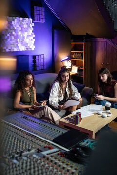 Music producers reviewing notes in a recording studio lounge