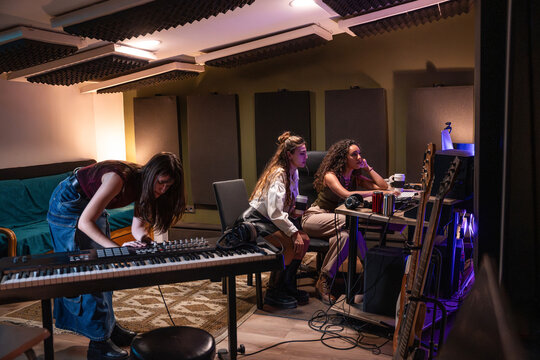 Musician recording and mixing track in a home studio room