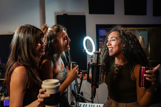 Friends recording a joyful podcast in a home studio
