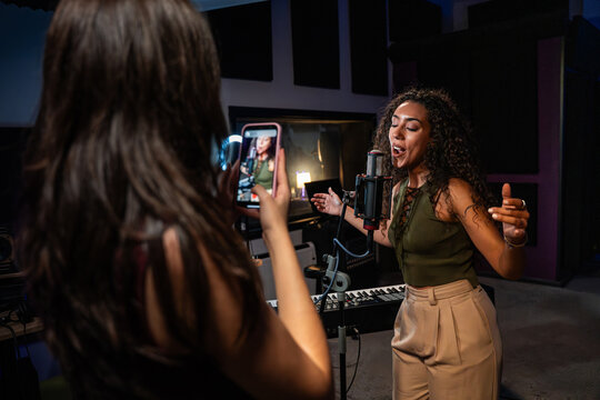 Female singer recording vocal performance in home studio