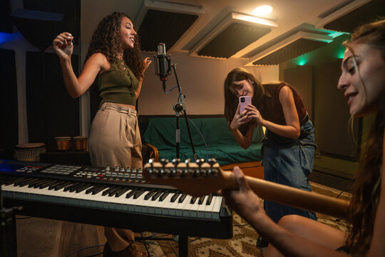 Women recording a live music jam in a home studio room