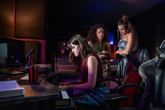 Young women producing music in a modern recording studio