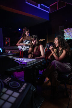 Music producer and vocalist recording in a neon studio