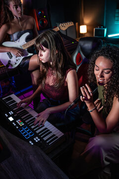 Musician recording pop track in home studio with keyboard