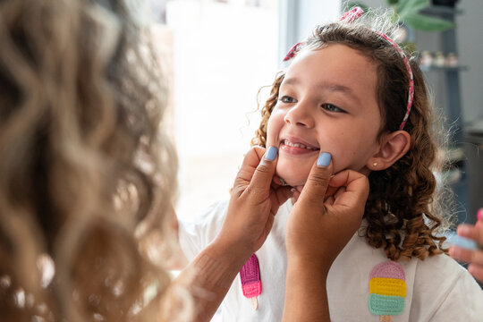 Adult checking child smile during home dental care routine