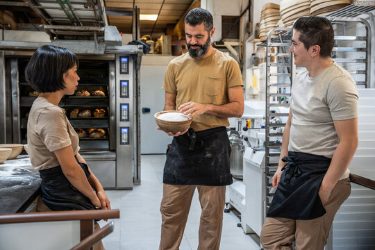 Bakers discuss dough and sourdough baskets in bakery