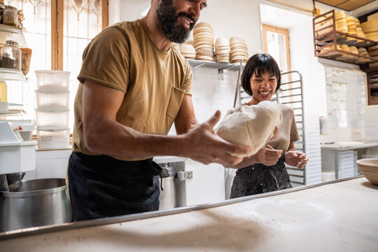 Artisan bakery team kneading dough in a bright workspace