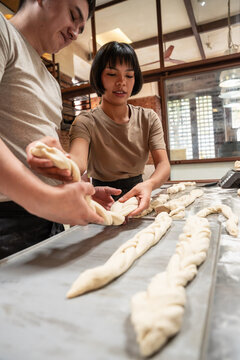 Bakers shaping dough for artisan bread in a warm bakery