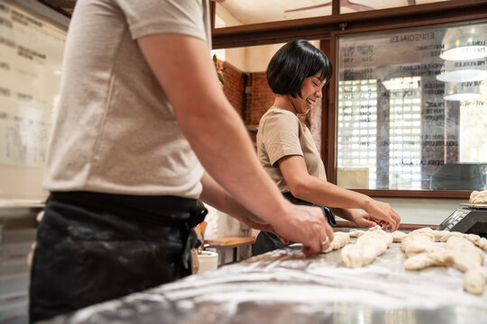 Artisan bakers shaping fresh dough on floured table
