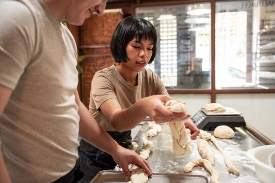 Baker shaping fresh dough in artisan bakery kitchen