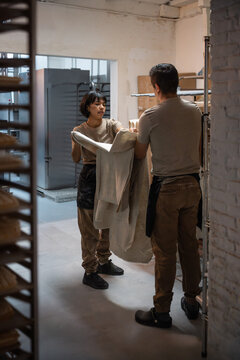 Bakers preparing linen proofing cloth in artisan bakery