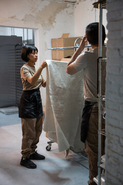 Bakers preparing linen proofing cloth in artisan bakery