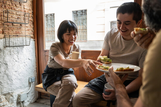 Bakery staff sharing lunch break in rustic cafe corner