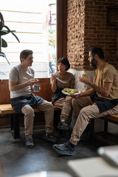 Bakery staff sharing lunch break in rustic cafe corner