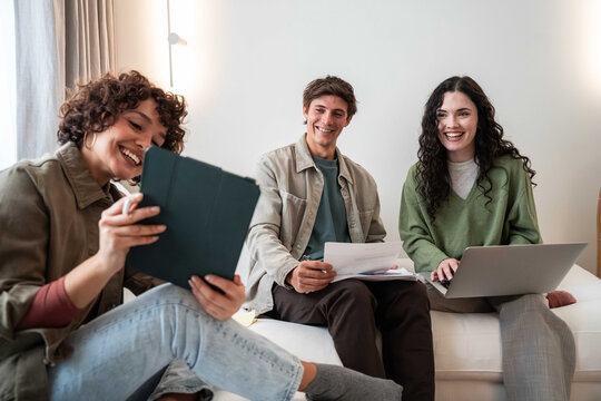 Young adult team meeting at home with laptop and notes