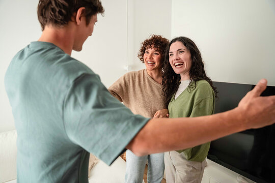 Friends greeting at home with warm welcome and laughter