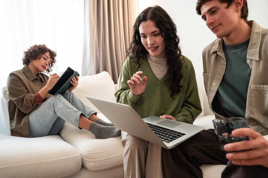 Friends plan a project on laptop in cozy living room