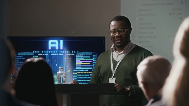 Medium shot of young African American male presenter standing in front of audience behind podium pointing at digital screen and speaking about AI technology during business conference