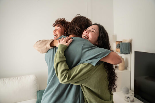 Friends hugging at home with joy and warm connection