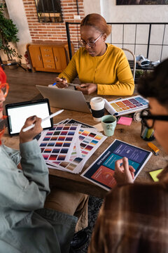 Creative team meeting with color palette and laptop