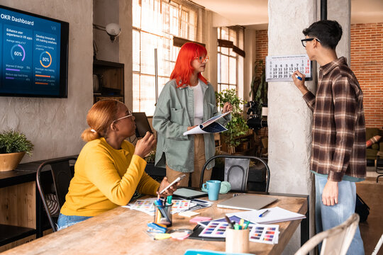 Diverse team planning schedule in modern creative studio