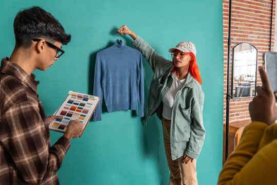 Fashion team styling sweater in studio with color palette