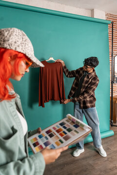 Stylist selecting a sweater for a studio fashion shoot setup