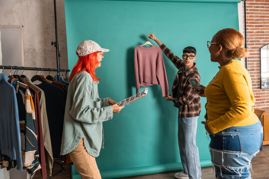 Fashion team styling knit sweater for studio photoshoot