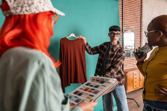Fashion team reviewing sweater sample during photo shoot