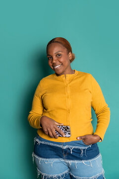 Smiling woman holding smartphone in casual outfit