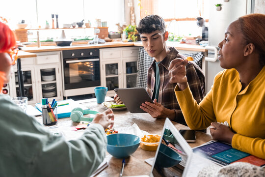 Diverse students studying and collaborating at kitchen table