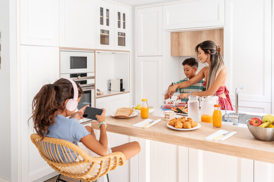 Hispanic family preparing breakfast in modern kitchen at home