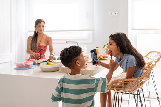 Hispanic family enjoying breakfast with video call at home